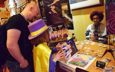 Member and child shop at a vendor in Artist Alley at Soonercon