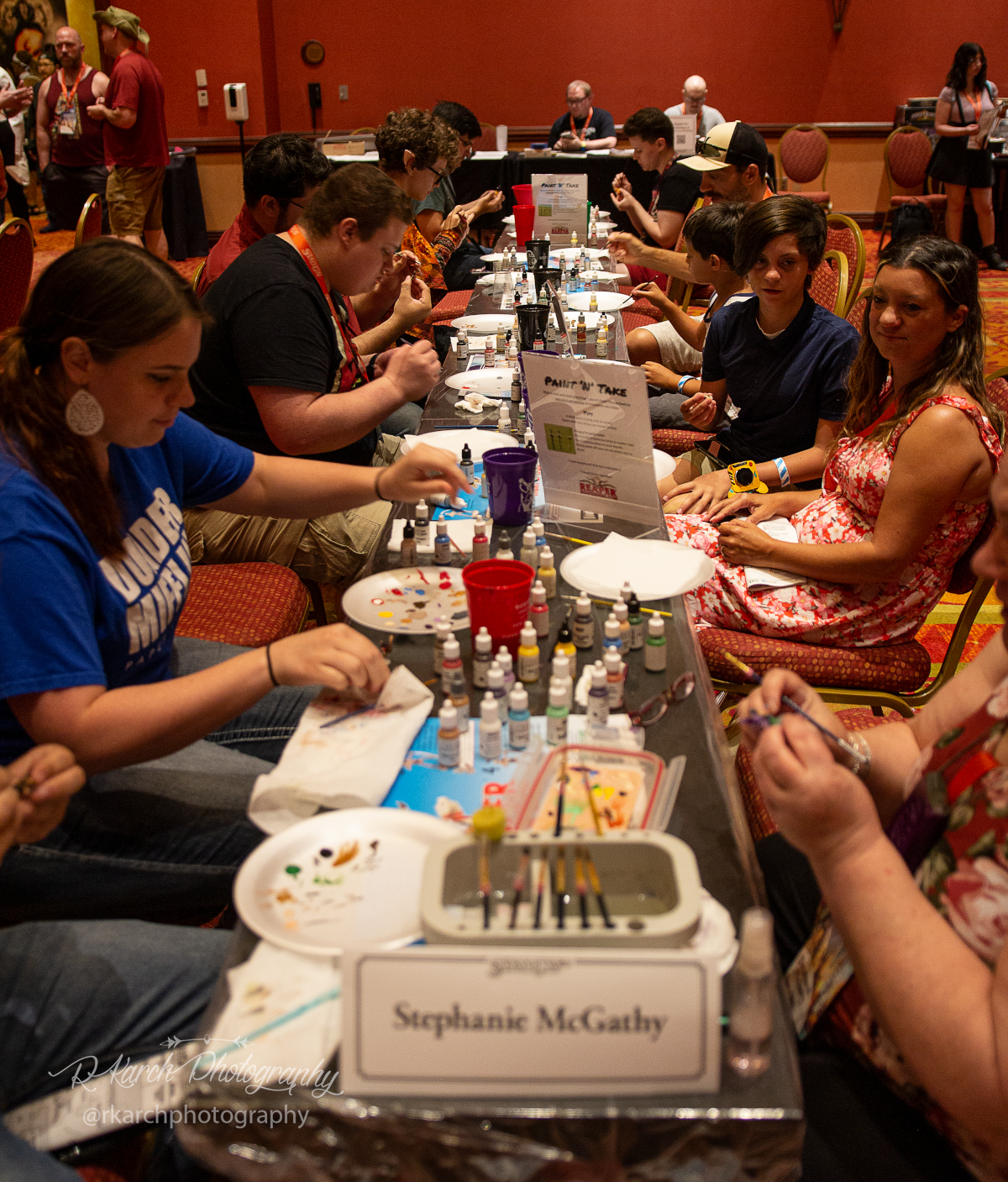 Guests sit around a table painting miniatures