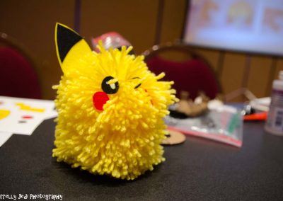 A closeup of a pom Pikachu craft made of yarn.