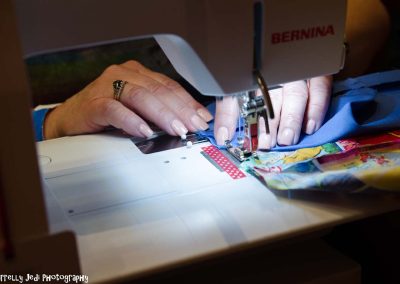 A closeup detail shot of a woman sewing on a Bernina sewing machine