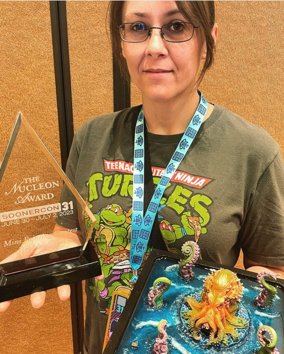 Best in show winner poses with winning miniature and trophy