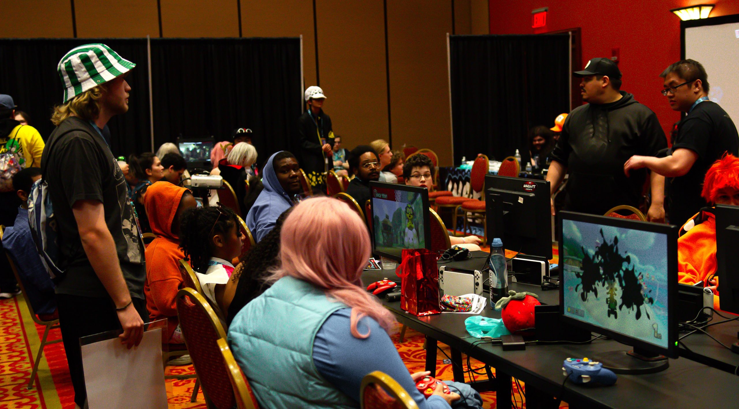 IMG_7150 A group of gamers are seat at consoles in front of games, participating in a video game tournament at Soonercon.